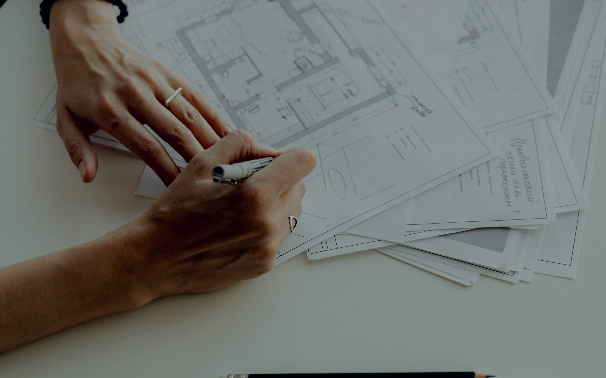 Architect marking revisions by hand on a detailed building floor plan